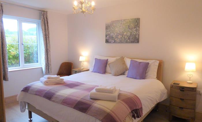 Bedroom 4 (ground floor) with superking size bed or 2x single beds, smart TV, with views over pasture land and hills.